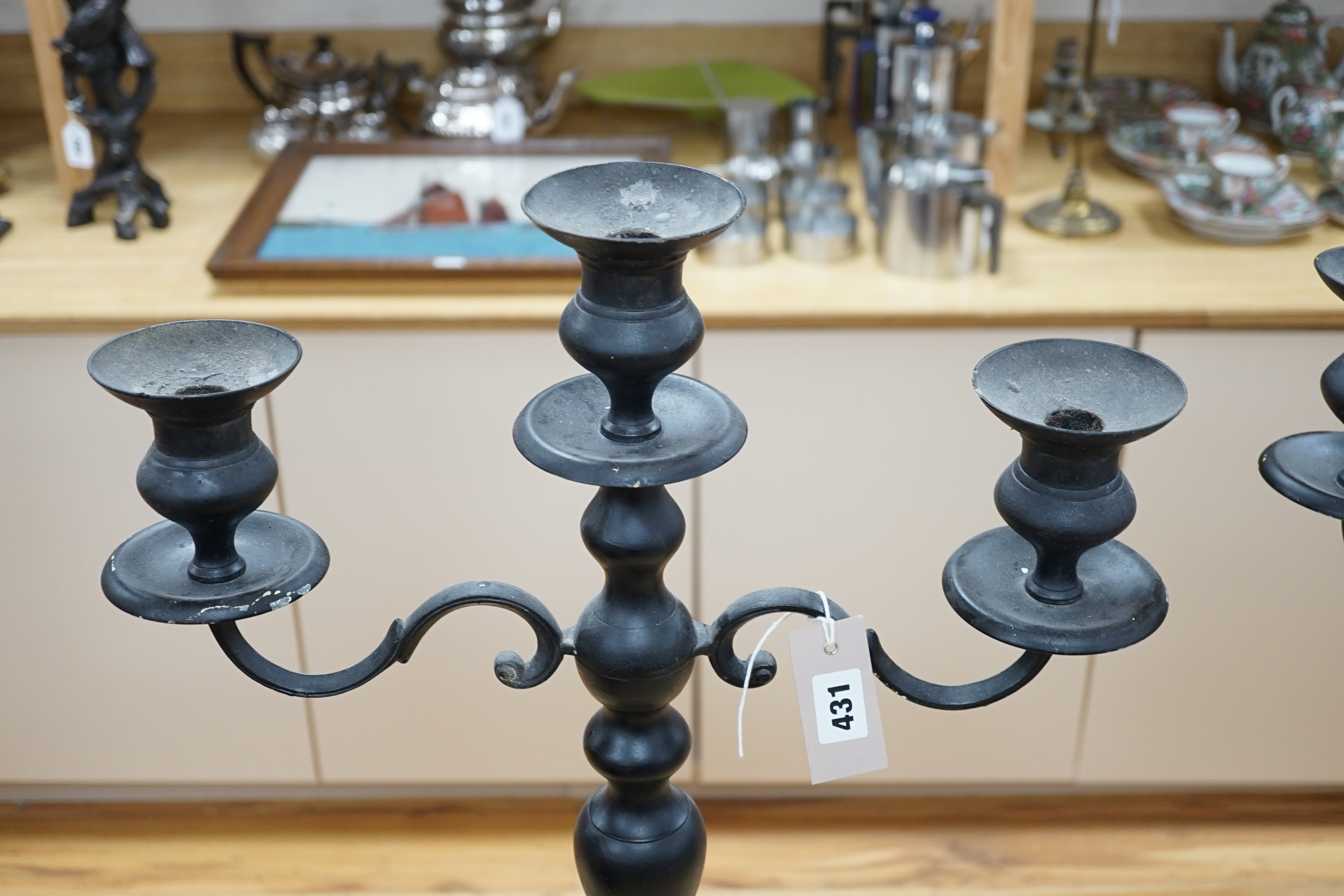 A pair of metal three branch candelabra, 60cm high